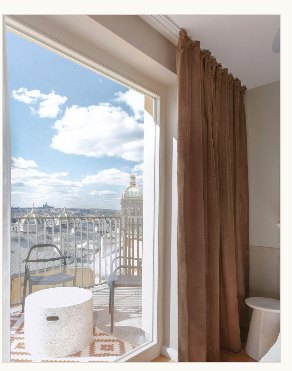 Bodentiefes Fenster mit Blick über die Dächer der Stadt
